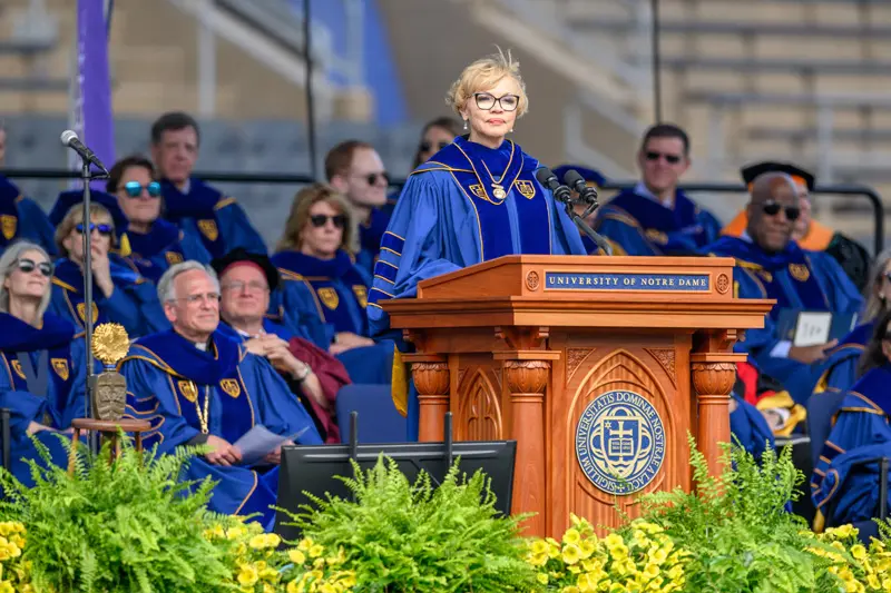 Claire Babineaux-Fontenot, chief executive officer of Feeding America, at the 2024 Commencement Ceremony in Notre Dame Stadium. She is wearing blue robes and glasses.