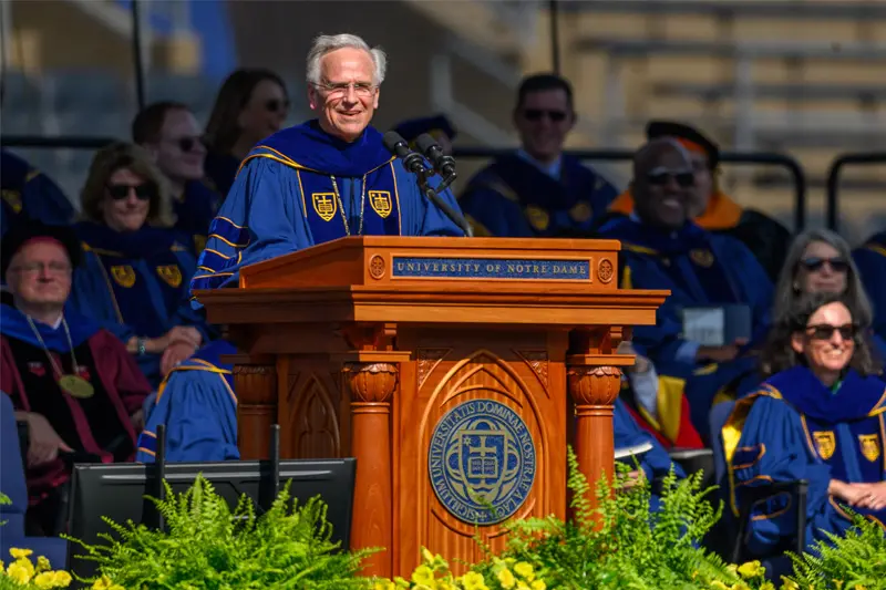 Father John I. Jenkins stands at a podium looking out on the class of 2024.