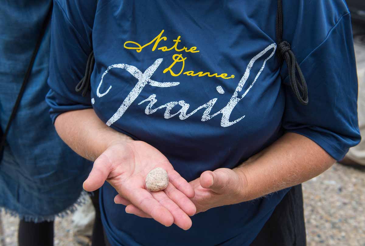 A pilgrim holds her rock outside the Basilica of St. Francis Xavier at the start of the ND Trail in Vincennes, Indiana.
